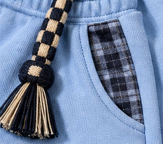 Close-up: braided checkerboard drawcord and a pocket with plaid trim, Monaco Set in blue #color-blue